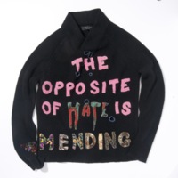 Embroidered and mended “The Opposite of Hate is Mending” sweater